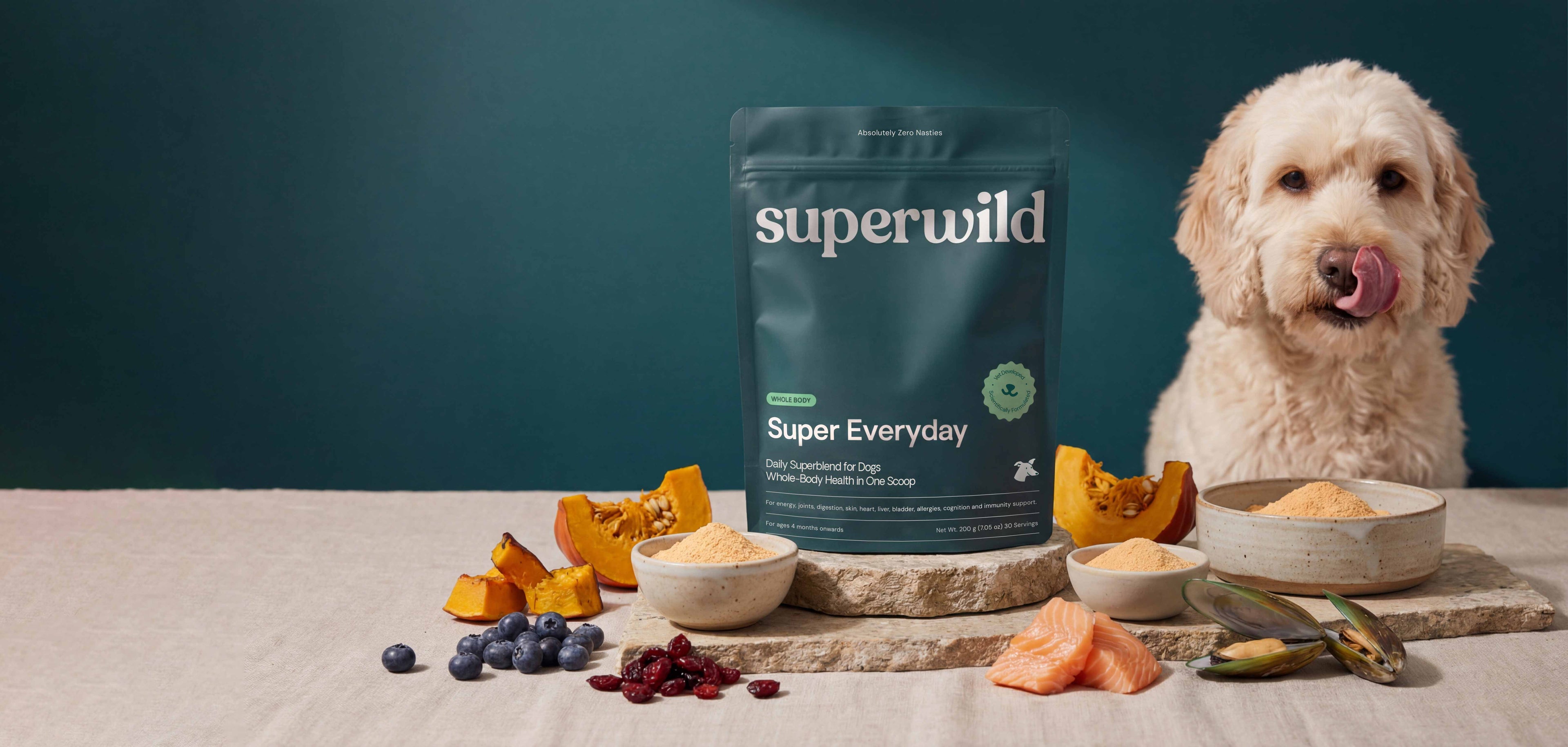Superwild Super Everyday dog supplement powder jar with natural ingredients spread across dark surface